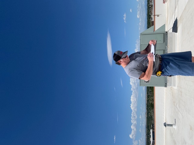 4 Peaks technician recording inspection findings on a commercial roof